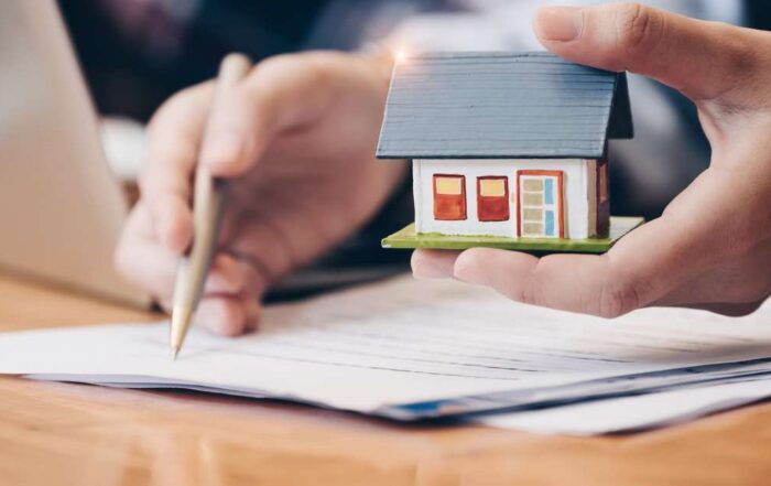 real estate agent with house figurine