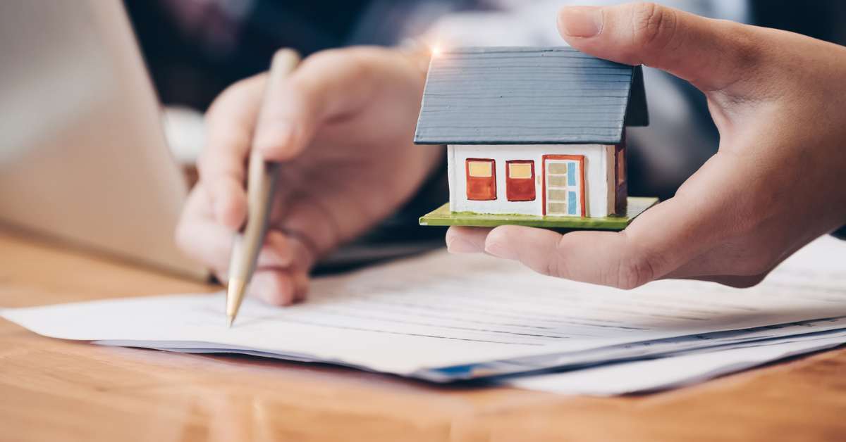 real estate agent with house figurine