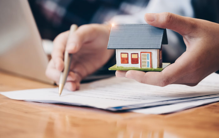 real estate agent with house figurine